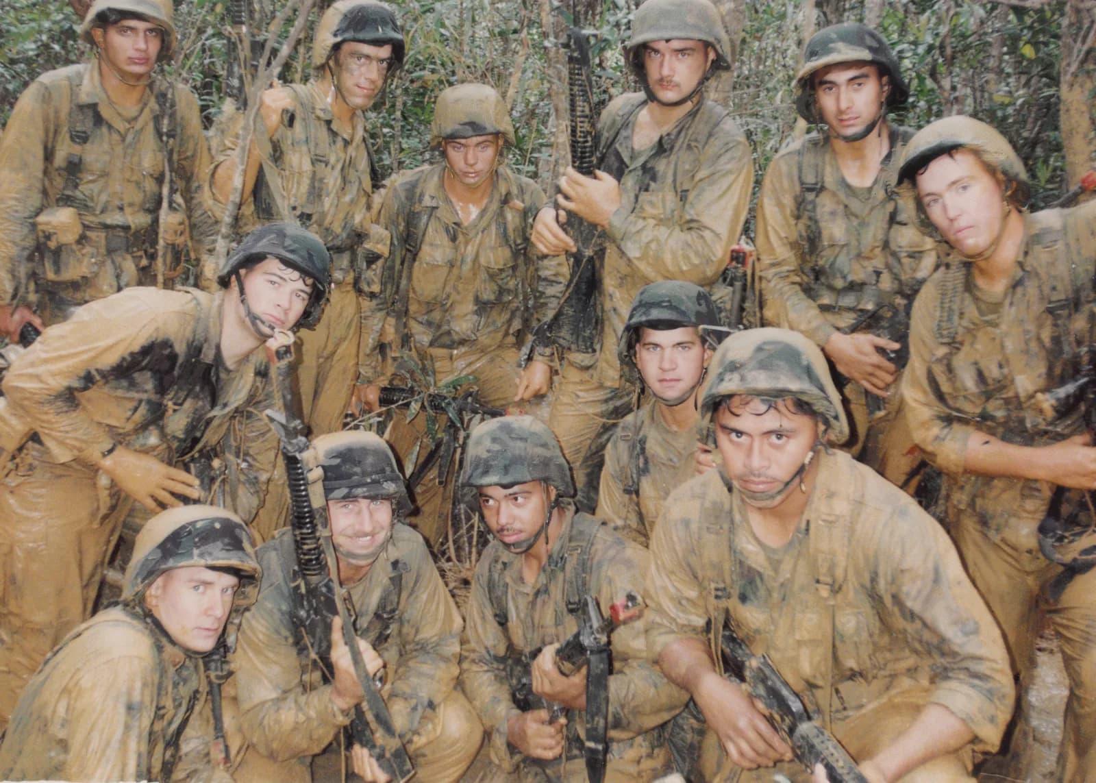 Marines in field gear posing in a wooded area